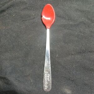 red and white plastic and metal baby spoon from the "First Essentials" line by N